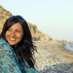 Indian woman sitting in blanket on the beach