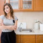 Petite brunette woman standing in kitchen at work