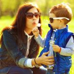 Young mom playing outside with her son