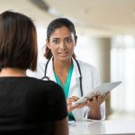 brunette woman talking to her doctor