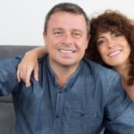 couple sitting at home on sofa taking a selfie