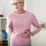 mature woman at home experiencing stomach pain