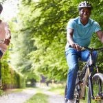 middle age couple riding bicylces in park