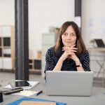 middle aged brunette woman sitting in office