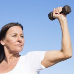 woman outside with hand weight