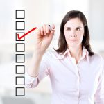 woman wearing white shirt checking off a checklist