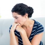 depressed woman sitting on couch