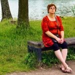 tired middle aged woman outside on park bench