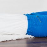 woman in blue pants laying on floor