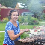 woman outside her home grilling dinner