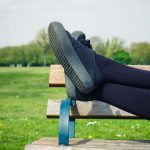 woman resting feet on park bench