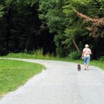 woman walking her dog in state park