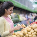 young woman buying potatoes